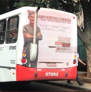 rear view of a bus with a printed vinyl wrap featuring a man and an exhaust pipe located in an inappropriate position