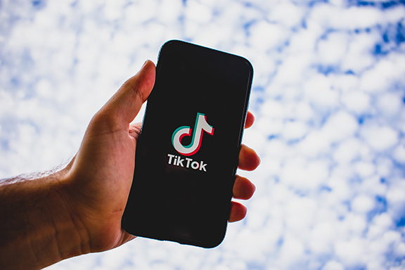 hand holding smart phone displaying TikTok logo