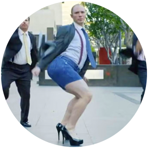 shot of silly British man outdoors wearing blazer, tie, shorts and high heel shoes