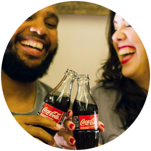 cropped closeup image of man and woman toasting with bottles of cola