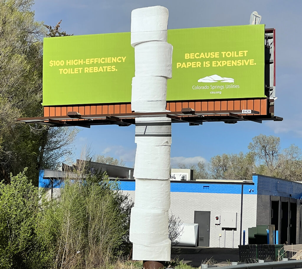 Outdoor billboard for Colorado Springs Utilities using graphic extensions and a pole wrap for the artwork that depicts a stack of toilet paper rolls