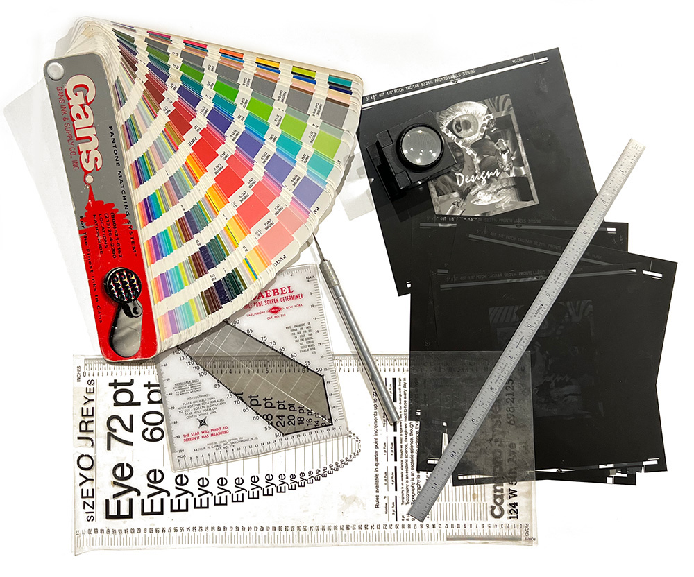 image of film negatives, ink swatch book, xacto knife, metal rule, and type size guide.